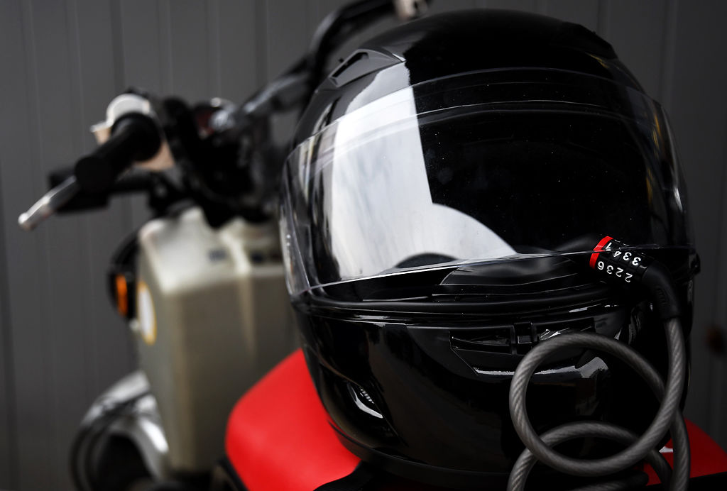 To prevent theft, a helmet is chained to a scooter